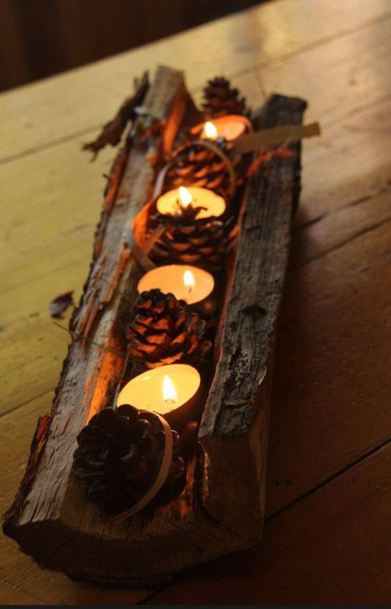 a tree stump with pinecones and tealights is a cool rough rustic centerpiece that will scream fall