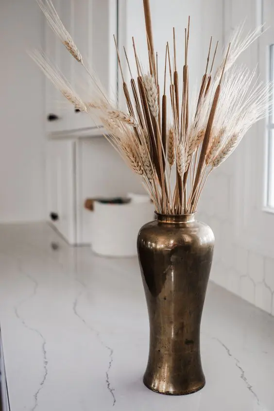 a vintage metal vase with cane and wheat is a cool fall decoration to go for