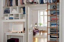 a whole open closet with lots of shelves is integrated over the door and on both sides to save as much space as possible