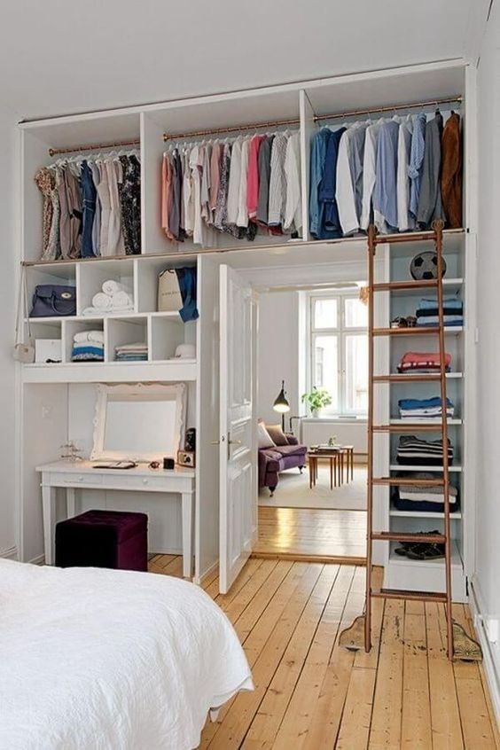 a whole open closet with lots of shelves is integrated over the door and on both sides to save as much space as possible