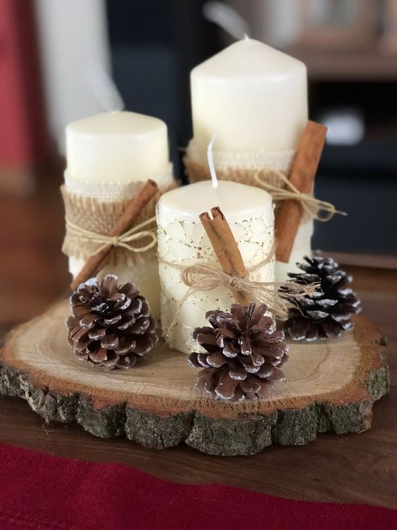a wood slice with pinecones, pillar candles, cinnamon and burlap are a cool centerpiece for fall or winter