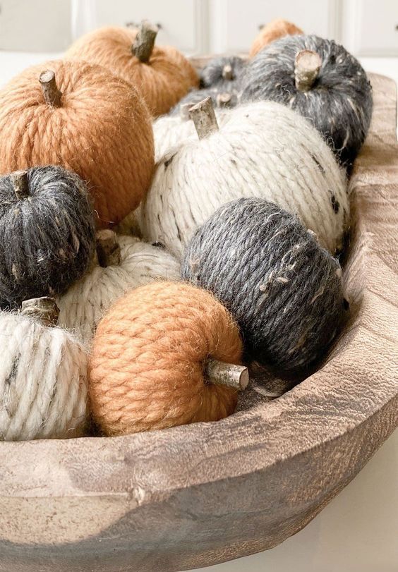 a wooden bowl with twine covered pumpkins and wooden stems is a simple rustic decoration for the fall