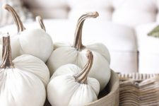 a wooden tray with white fabric pumpkins with natural stems is a simple and natural-looking fall decoration or centerpiece
