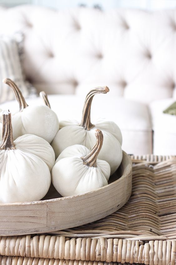 A wooden tray with white fabric pumpkins with natural stems is a simple and natural looking fall decoration or centerpiece