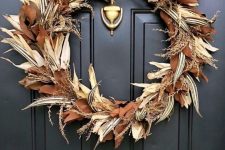 an elegant fall wreath made of corn husks, striped leaves, wheat and some magnolia leaves will give timeless elegance to the space