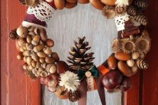 an eye-catchy fall to winter wreath of acorns, nuts, pinecones, dried blooms, lace, ribbon and a twine bow is a cool idea