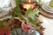 fall table decor with heirloom pumpkins, fall leaves, candle lanterns with pinecones is very cozy