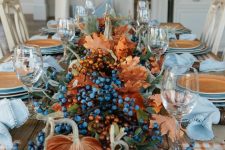 rust velvet pumpkins, berries, greenery and dried fall leaves for a large and bold fall centerpiece