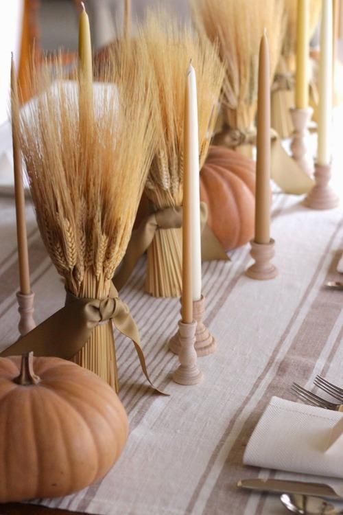rustic fall decor with neutral candles, wheat bundles and chalked pumpkins for a vintage feel