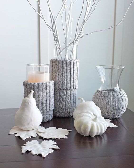 white faux veggies and fruits, white fall leaves, vases with whitewashed branches, candles with grey knit cozies