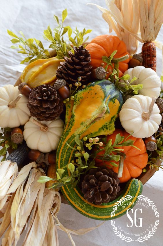 a Thanksgiving centerpiece of gourds, pumpkins, foliage, corn, acorns and pinecones