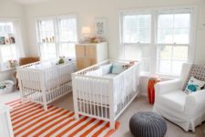 a bright and fun shared nursery done with IKEA Sundvik cribs, bold orange and turquoise touches, soem cozy chairs and cabinets