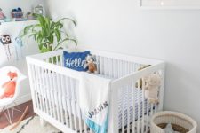 a bright beach-inspired nursery with a white Sundvik crib, baskets, open shelving, a beach artwork and some printed textiles