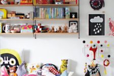 a colorful kid’s room with lots of artworks, a large bookshelf, toys, pillows and a white Sundvik bed