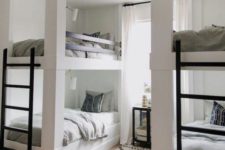 a contemporary neutral kids’ room with two bunk bed units, metal ladders and wall lamps over each bed
