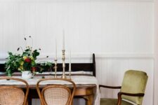 a country style dining room with a vintage stained table, some matching chairs, an antique green chair and a black bench