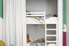 a cozy and bright kids’ room with white built-in bunk beds, neutral bedding, a mustard chair and a curtain to get some privacy