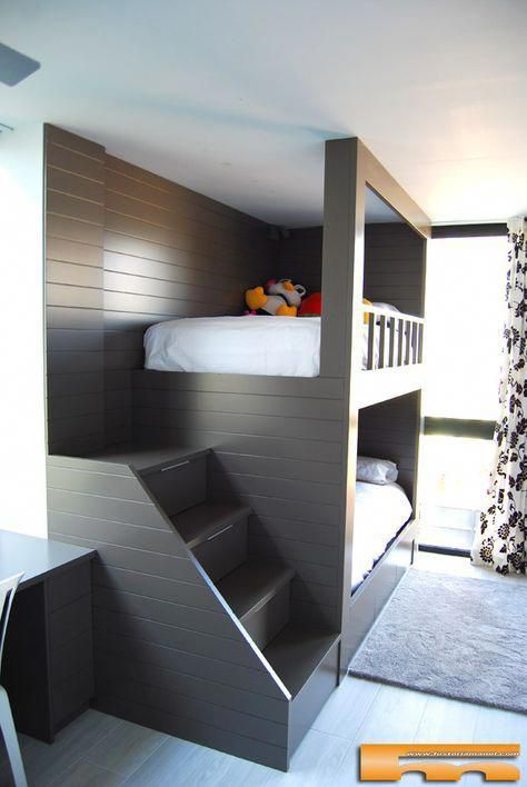 a dark stained ubnk bed unit with a staircase and wall lamps at the headboard of the bed