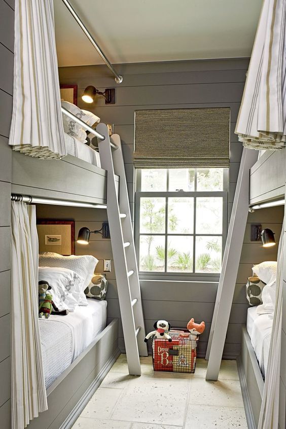 a grey farmhouse kids' room with shiplap walls, built-in bunk beds and neutral bedding, ladders and curtains for privacy