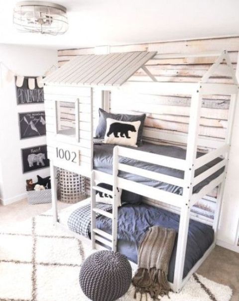 A house shaped bunk bed unit for two, built in lights and a ladder to reach the upper bed