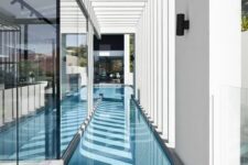 a long and narrow pool built inside a minimalist house is a stylish and cool idea to swim in all weathers