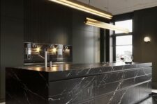 a luxurious black kitchen with sleek cabinets, built-in appliances, a large marble kitchen island and pendant lamps