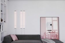 a minimalist living room with a graphite grey low sofa, a coffee table, a pink artwork and pink neon lights, a pink sofa