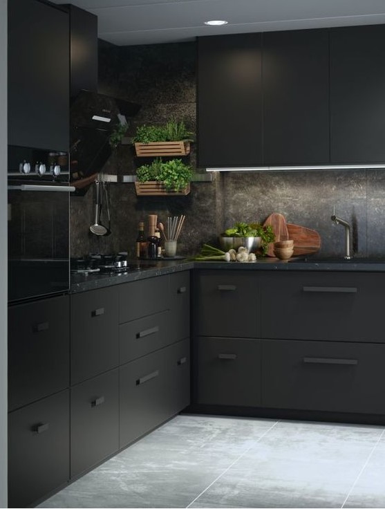 a minimalist meets industrial black kitchen with metal cabinets, black stone countertops and a backsplash plus greenery