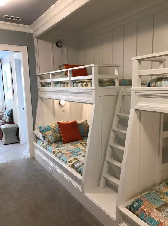 A modern kids' room with built in bunk beds, bright printed bedding, built in lights is a cool and welcoming space for children