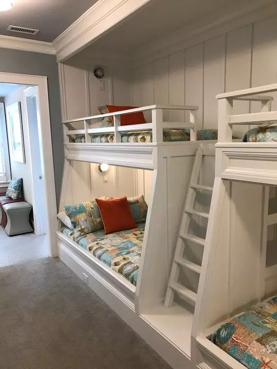 A modern kids' room with built in bunk beds, bright printed bedding, built in lights is a cool and welcoming space for children
