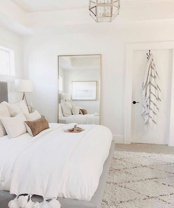 a neutral farmhouse bedroom looks bigger thanks to the neutral color scheme and thanks to a large mirror