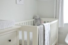 a neutral soothing nursery done in dove grey and off-whites, with an IKEA Sundvik crib and cozy and cute toys