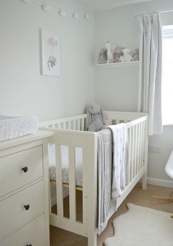A neutral soothing nursery done in dove grey and off whites, with an IKEA Sundvik crib and cozy and cute toys