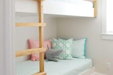 a pretty and cozy kids’ room with white built-in bunk beds, pastel bedding and toys is a cozy space to sleep in