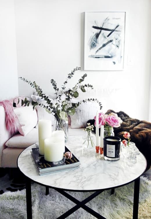 a refined arrangement of pillar candles, magazines, bright blooms in clear vases and eucalyptus in a clear vase