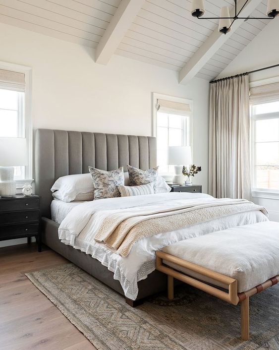 a small bedroom made larger with an extended headboard and with a neutral color scheme
