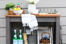 a stylish outdoor bar or grill cart made of an IKEA Forhoja cart painted graphite grey and with a wooden countertop