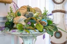 a vintage stone stand with faux greenery and leaves, blooms and velvet pumpkins for timeless fall decor