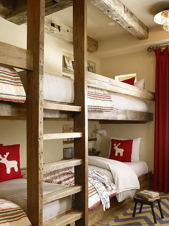 A welcoming kids' room with stained built in bunk beds, with a ladder and bright and neutral bedding, a rug and curtains