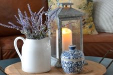 a wooden tray with a vintage candle lantern, a white jug with lavender and a blue patterned sugar pot for small stuff