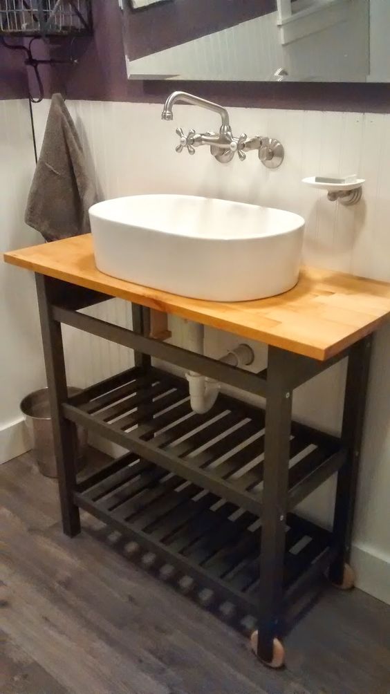 an IKEA Forhoja cart hacked with black paint and with a butcherblock countertop to make a cool rustic vanity