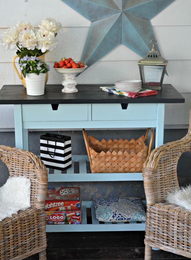 an IKEA Forhoja cart hacked with blue paint and with a chalkboard countertop is used for storage in the kitchen
