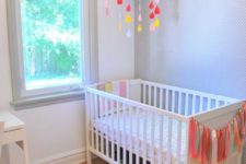 an airy and bright nursery with an IKEA Sundvik crib, colorful touches and decor and simple white furniture