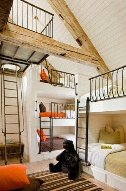 an awesome kids' room with several built-in bunk beds, bright and white bedding, metal ladders and a printed rug