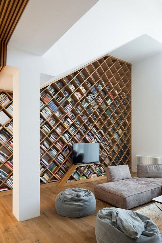 an ultra-modern home library with a bookcase with a geometric design plus contemporary furniture in greys