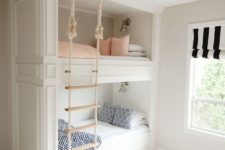built-in bunk beds with a rope ladder hanging from the ceiling make up a cozy and cute space for sleeping
