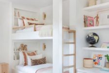 built-in bunk beds with built-in shelves and a ladder byt their side plus small and elegant wall lamps
