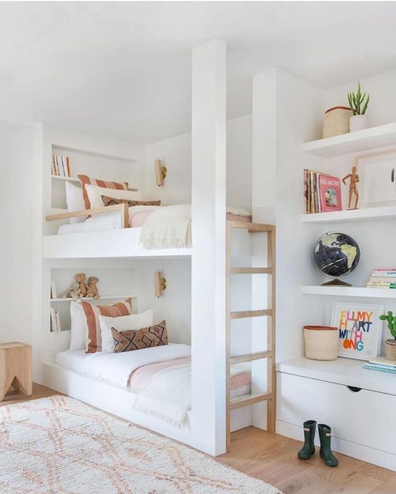 built-in bunk beds with built-in shelves and a ladder byt their side plus small and elegant wall lamps