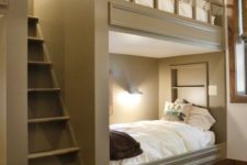 cozy grey bunk beds with a large ladder and wall lamps to make readin there comfortable