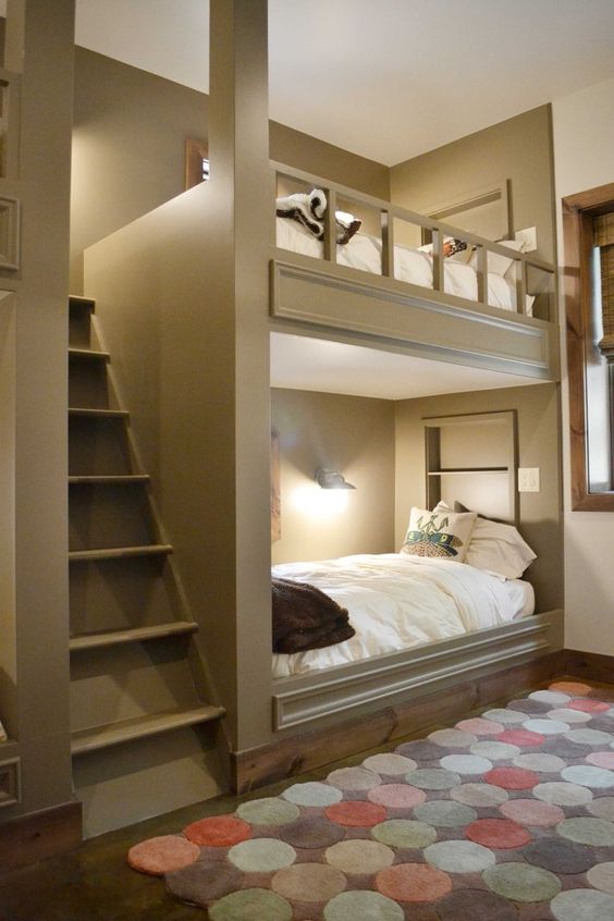cozy grey bunk beds with a large ladder and wall lamps to make readin there comfortable